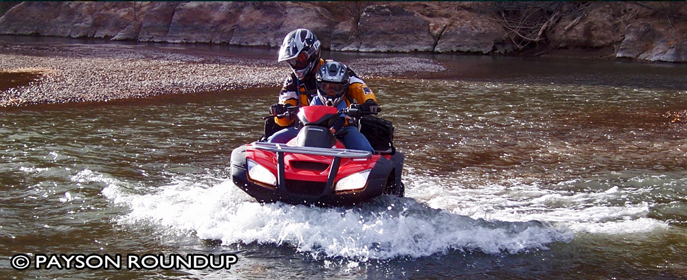 Picture from the Payson Roundup, of an ATV forging up a wet creek bed.